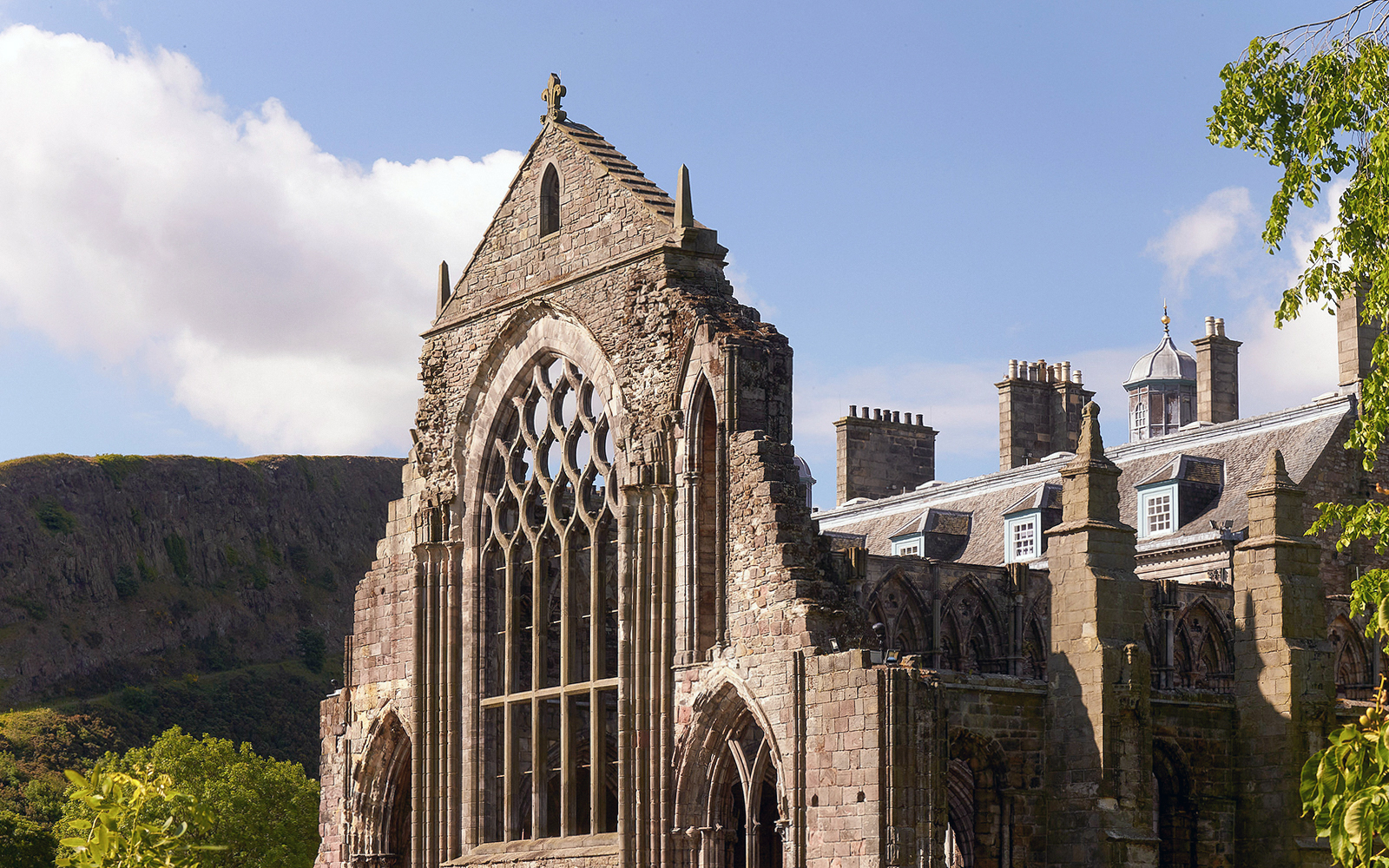 Palace of Holyroodhouse ruins with arched windows and stone facade in Edinburgh.