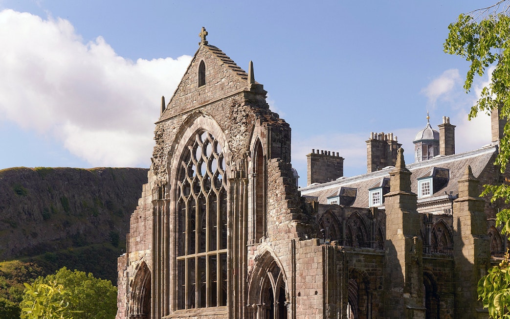 Palace of Holyroodhouse ruins with arched windows and stone facade in Edinburgh.