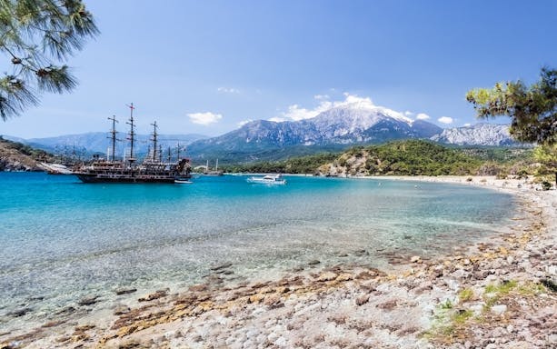 Pirate ship in Phaselis Bay with mountains in the background, Kemer boat trip.