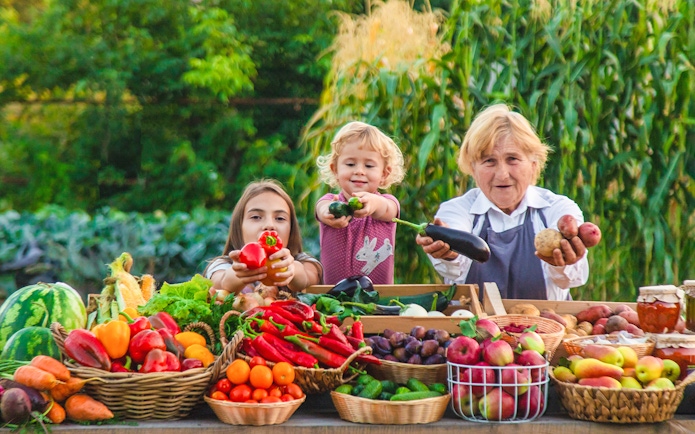 Family presenting fresh produce at a farm stand during Lavender Full Day Tour.