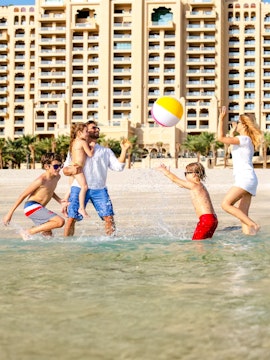 Family enjoying beach activities near Fairmont The Palm, Dubai.