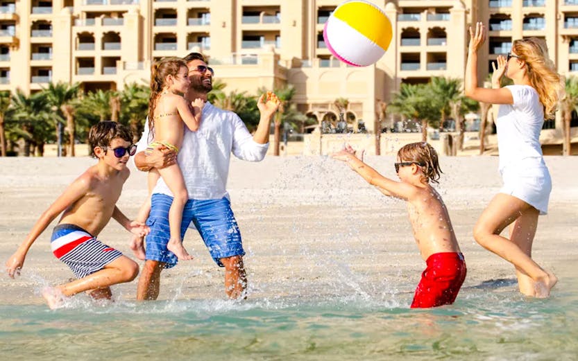 Family enjoying beach activities near Fairmont The Palm, Dubai.