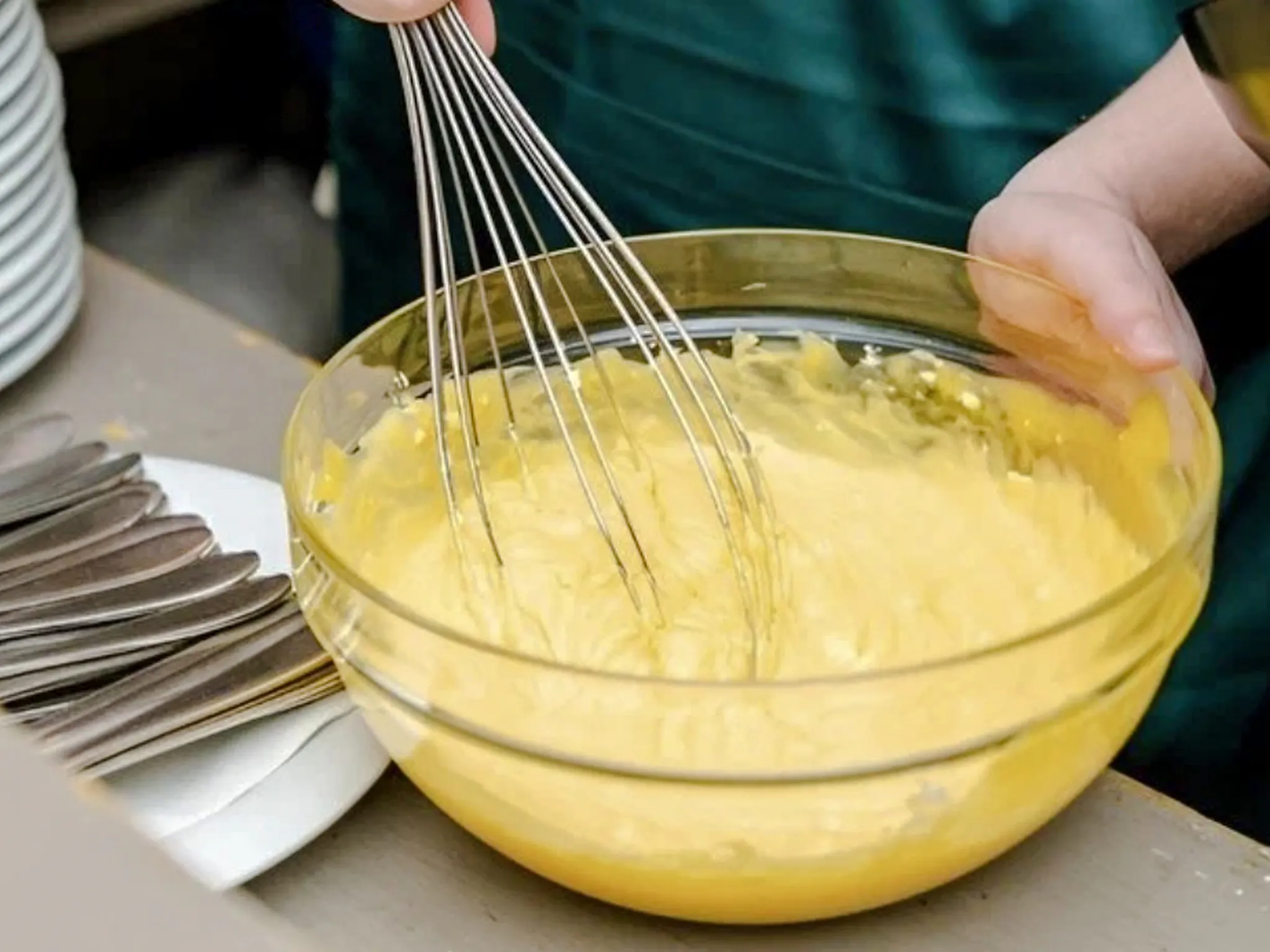 Whisking pasta dough in a bowl during a cooking class in Rome.