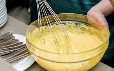 Whisking pasta dough in a bowl during a cooking class in Rome.