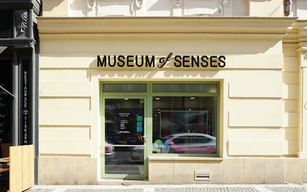 Entrance to the Museum of Senses with glass door and signage.