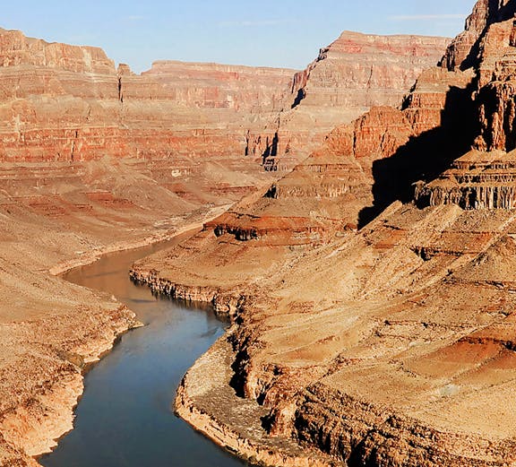Grand Canyon view with Colorado River winding through rocky landscape.
