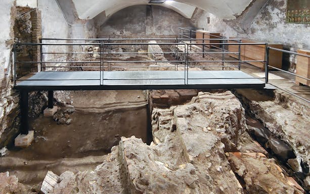 Archaeological excavation site beneath Basilica of San Marco with walkway.