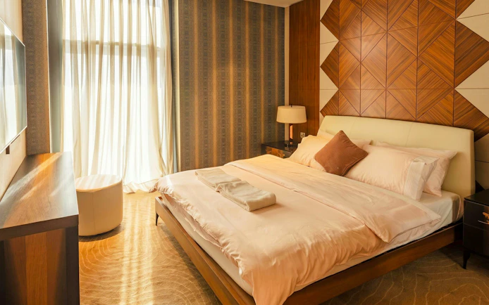 Luxurious bedroom in Primeclass Lounge at Muscat International Airport, featuring a neatly made bed.