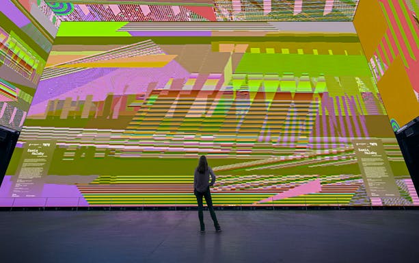 Person viewing Samia Halaby's "After the Green and After the Black Dune" 2024 installation.