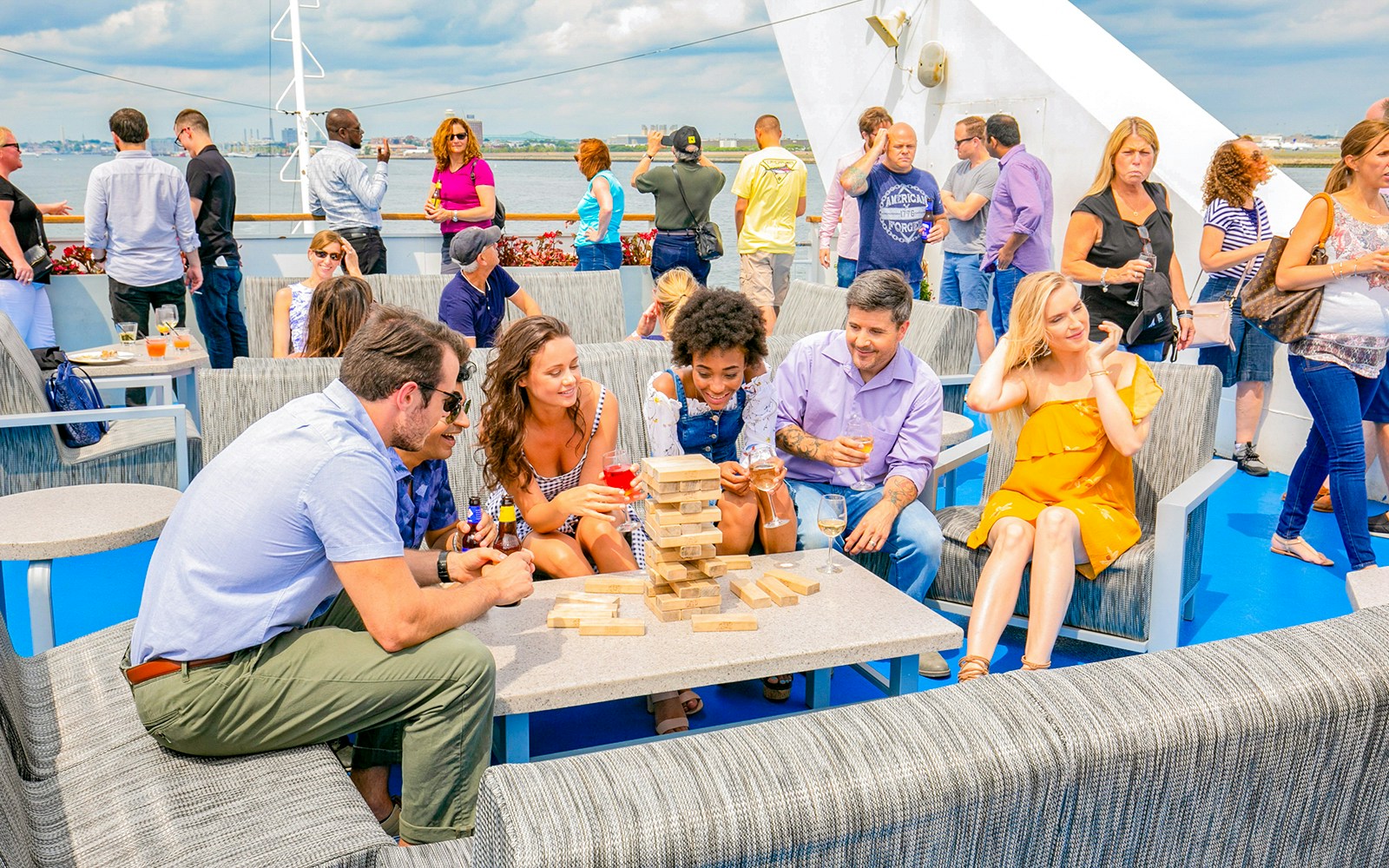 People enjoying a sunset party cruise on a boat in New York City.