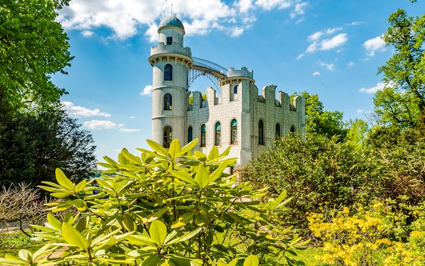 Peacock Island Palace surrounded by lush greenery on Berlin World Heritage Cruise to Potsdam.