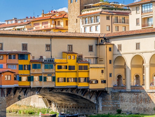 Vasari Corridor above Ponte Vecchio in Florence, Italy, with colorful buildings and river below.