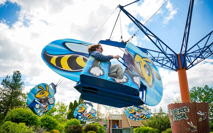 Hornet's Nest ride at Six Flags Darien Lake with bee-themed seats swinging in the air.