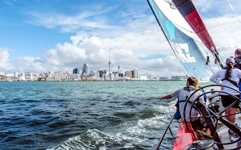 Sailing on Waitemata Harbour with Auckland skyline in view during America's Cup experience.