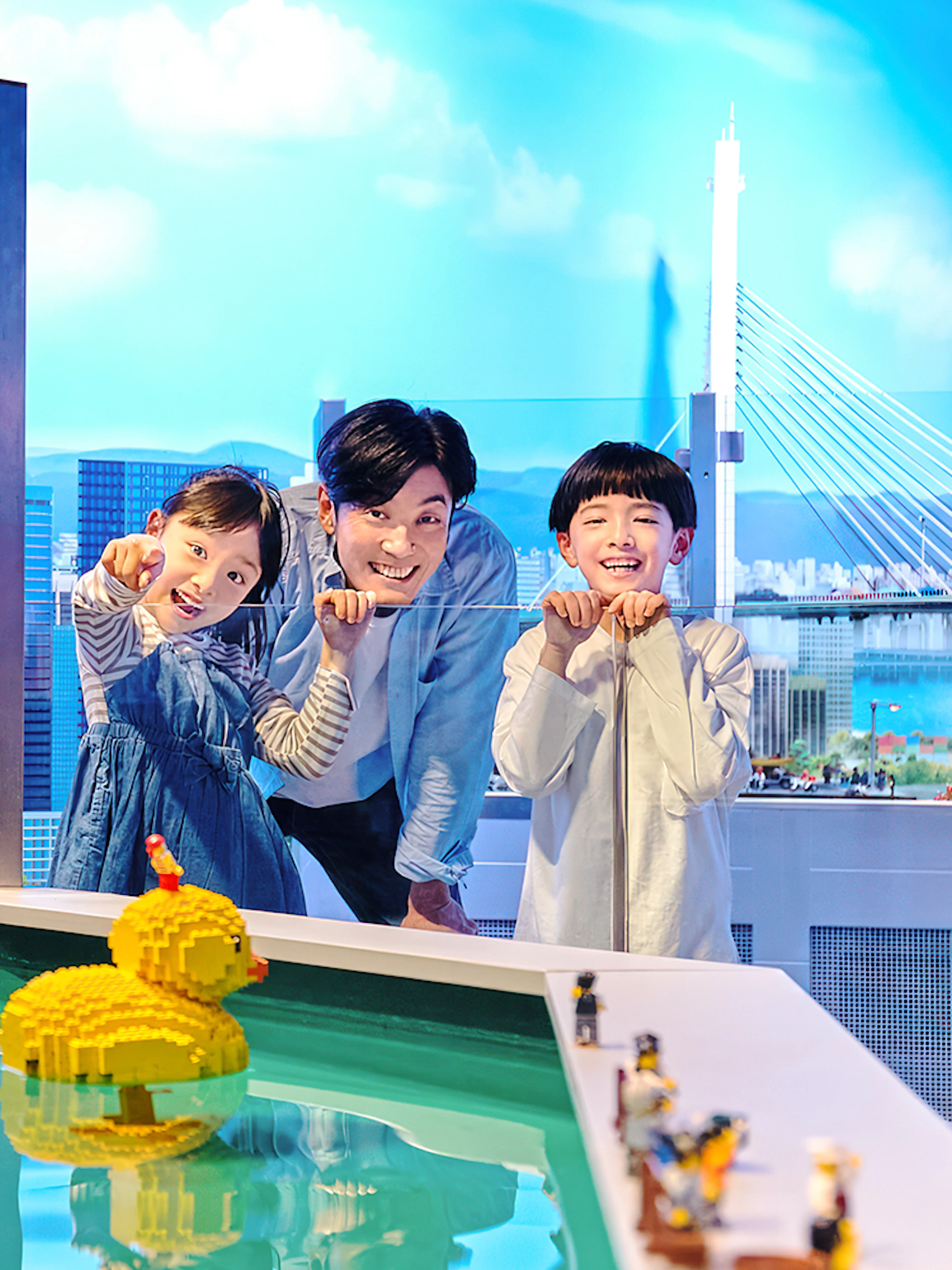 Family enjoying LEGO cityscape and duck model at LEGOLAND Discovery Center Osaka.