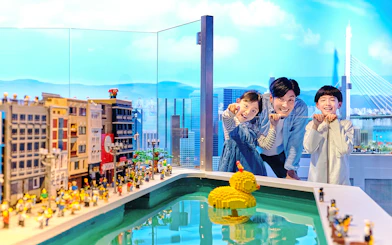 Family enjoying LEGO cityscape and duck model at LEGOLAND Discovery Center Osaka.