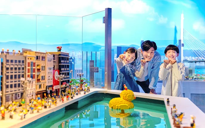 Family enjoying LEGO cityscape and duck model at LEGOLAND Discovery Center Osaka.
