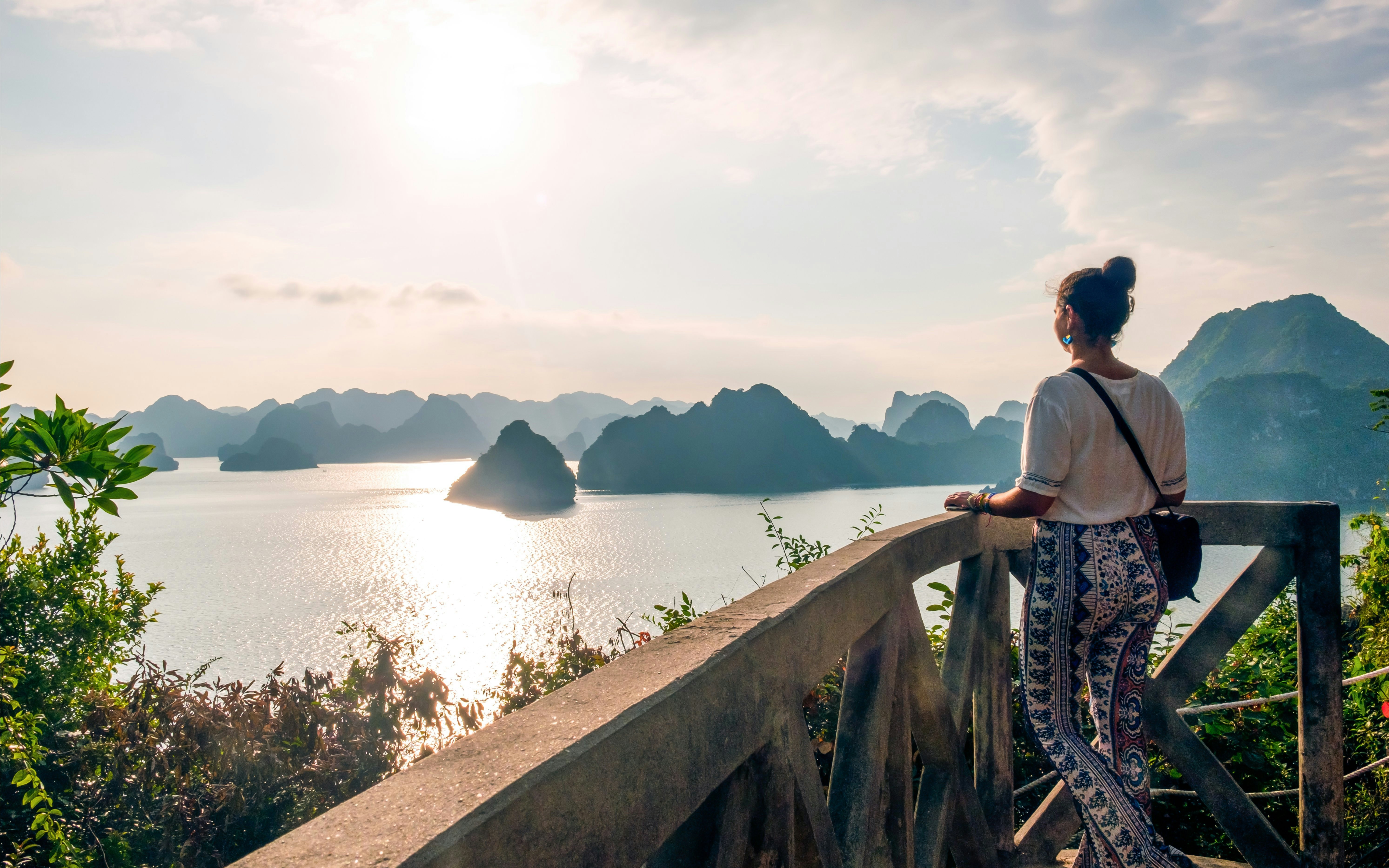 Person admiring sunset over Ha Long Bay from Titop Island viewpoint.