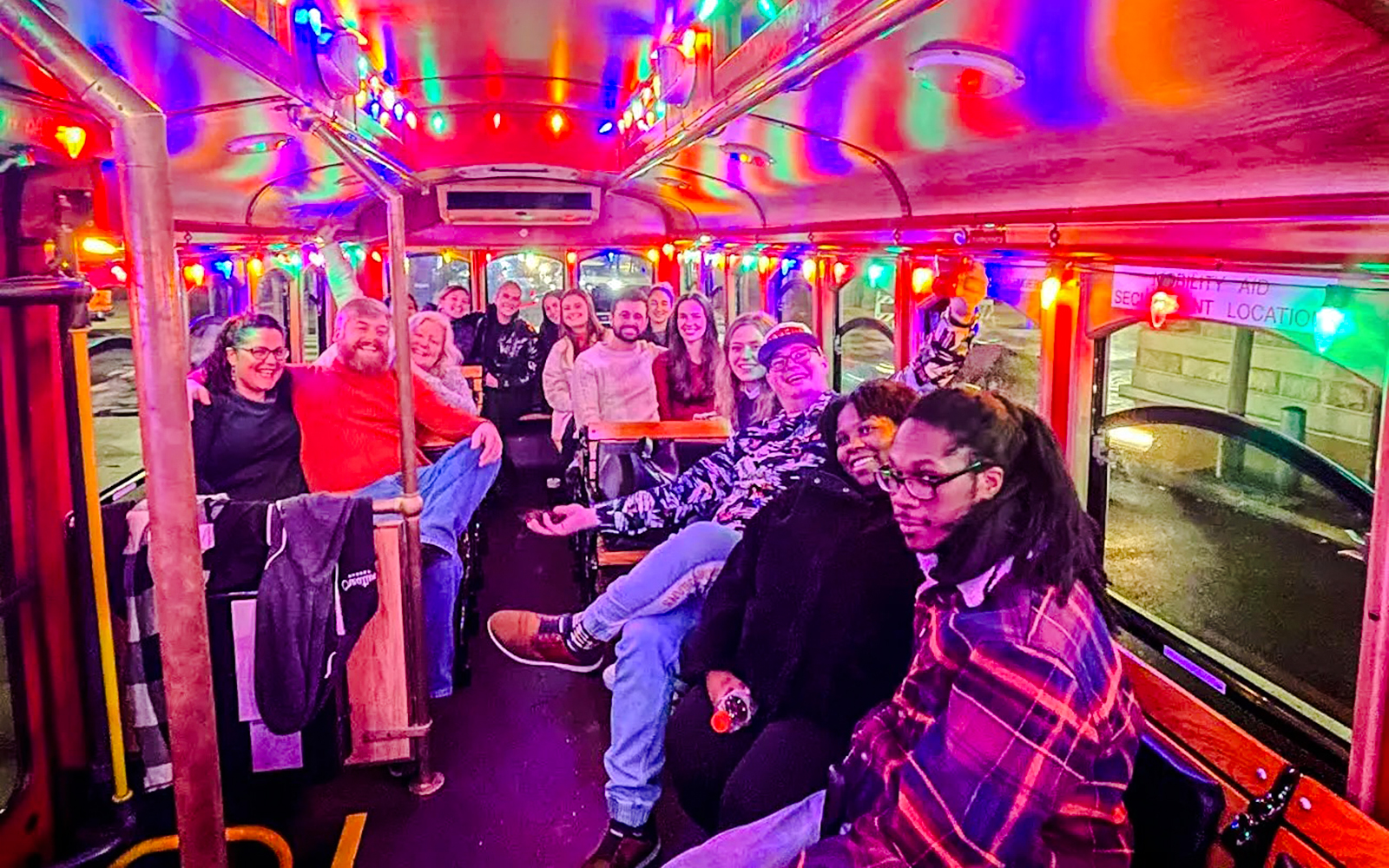 Passengers enjoying a festive trolley ride with colorful lights on the Holiday Lights Tour in Philadelphia.
