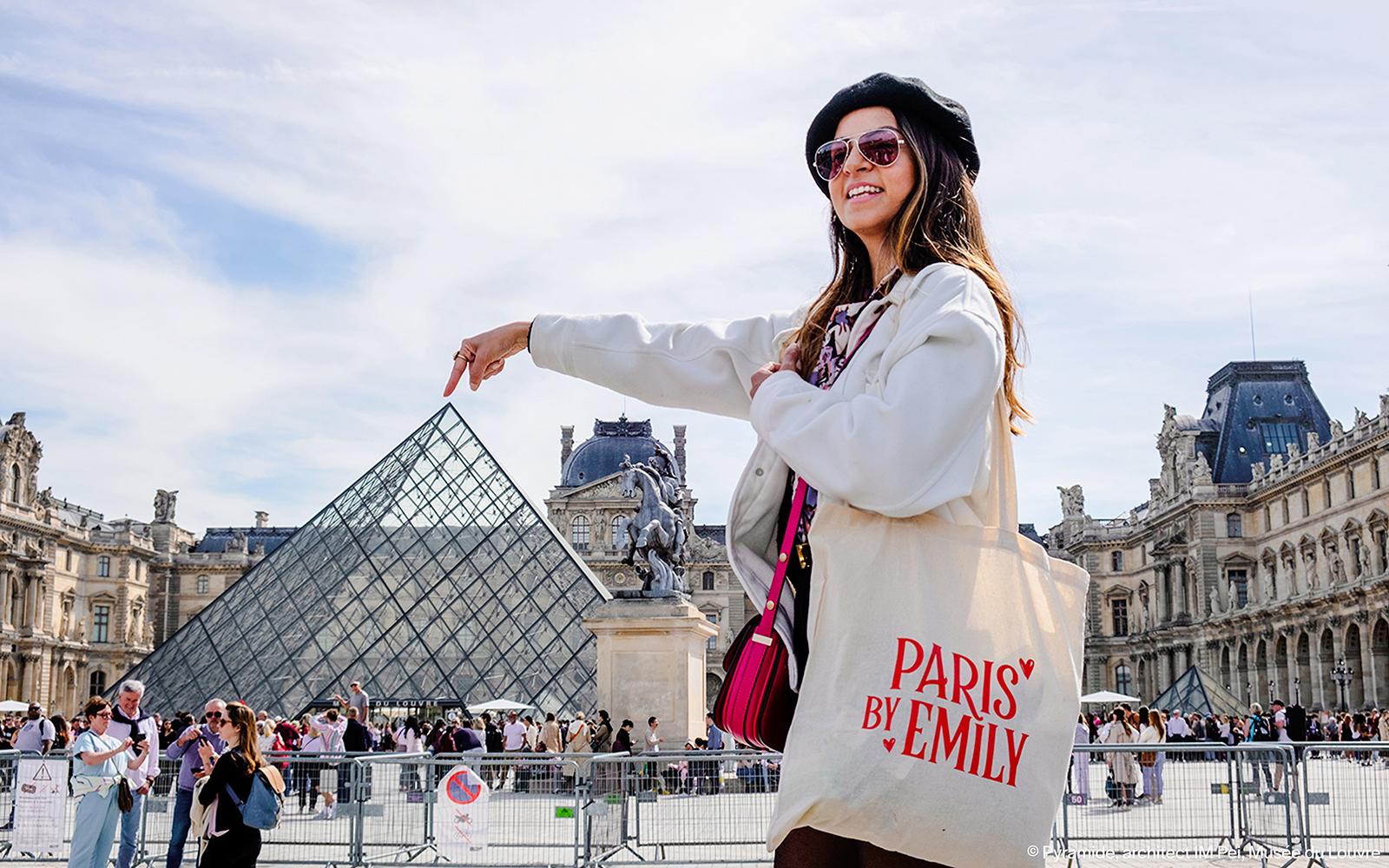 Person pointing at Louvre Pyramid during Emily in Paris Locations Walking Tour.