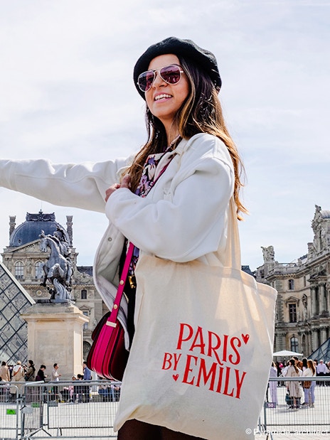 Person pointing at Louvre Pyramid during Emily in Paris Locations Walking Tour.