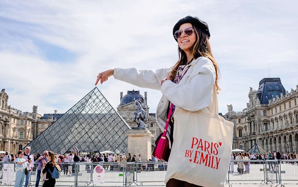 Person pointing at Louvre Pyramid during Emily in Paris Locations Walking Tour.