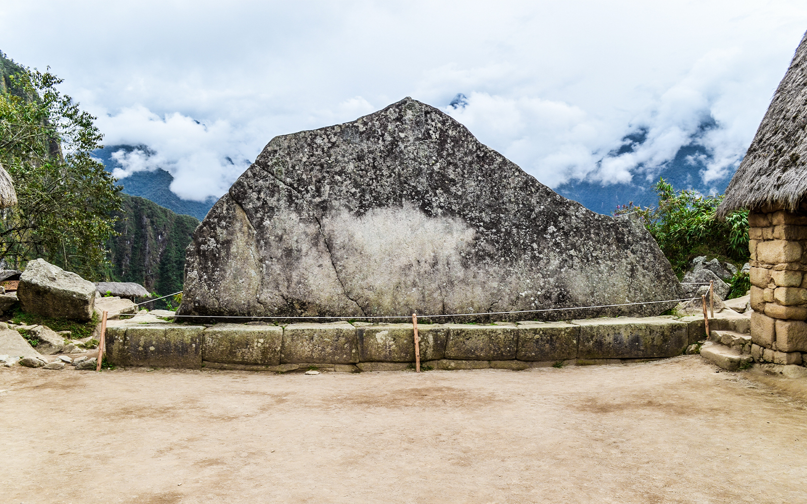 Sacred stone at Machu Picchu with mountain backdrop.