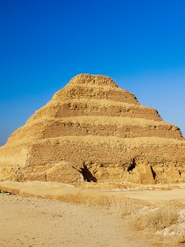 Step Pyramid of Djoser in Saqqara, Egypt under a clear blue sky.