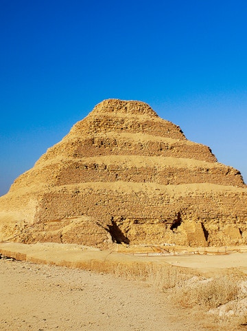 Step Pyramid of Djoser in Saqqara, Egypt under a clear blue sky.