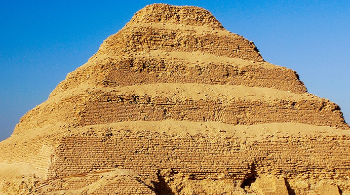 Step Pyramid of Djoser in Saqqara, Egypt under a clear blue sky.