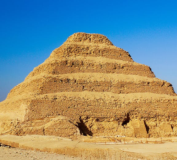 Step Pyramid of Djoser in Saqqara, Egypt under a clear blue sky.