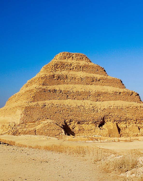 Step Pyramid of Djoser in Saqqara, Egypt under a clear blue sky.