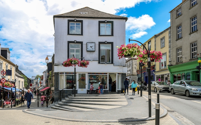 Central street in Kilkenny's old town with shops and hanging flowers.