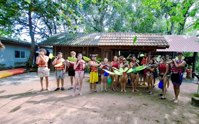 Group preparing for kayaking at Ao Thalane, Krabi, wearing life vests and holding paddles.