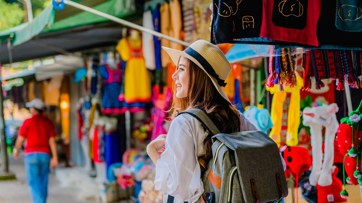 Traveler with a backpack exploring a colorful market.