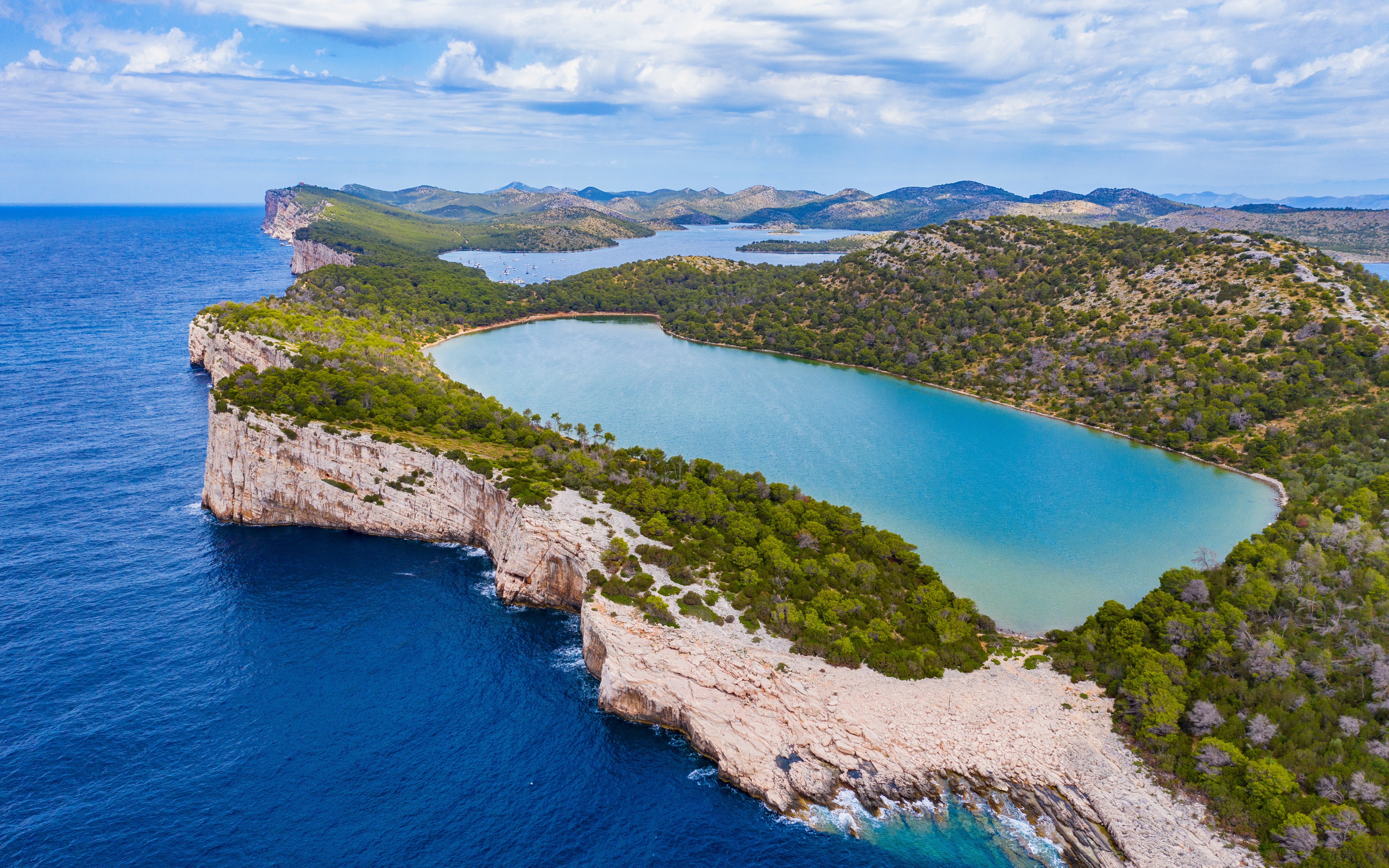 Cliffs and sea at Telascica Nature Park, Dugi Otok, Croatia, with lush greenery.