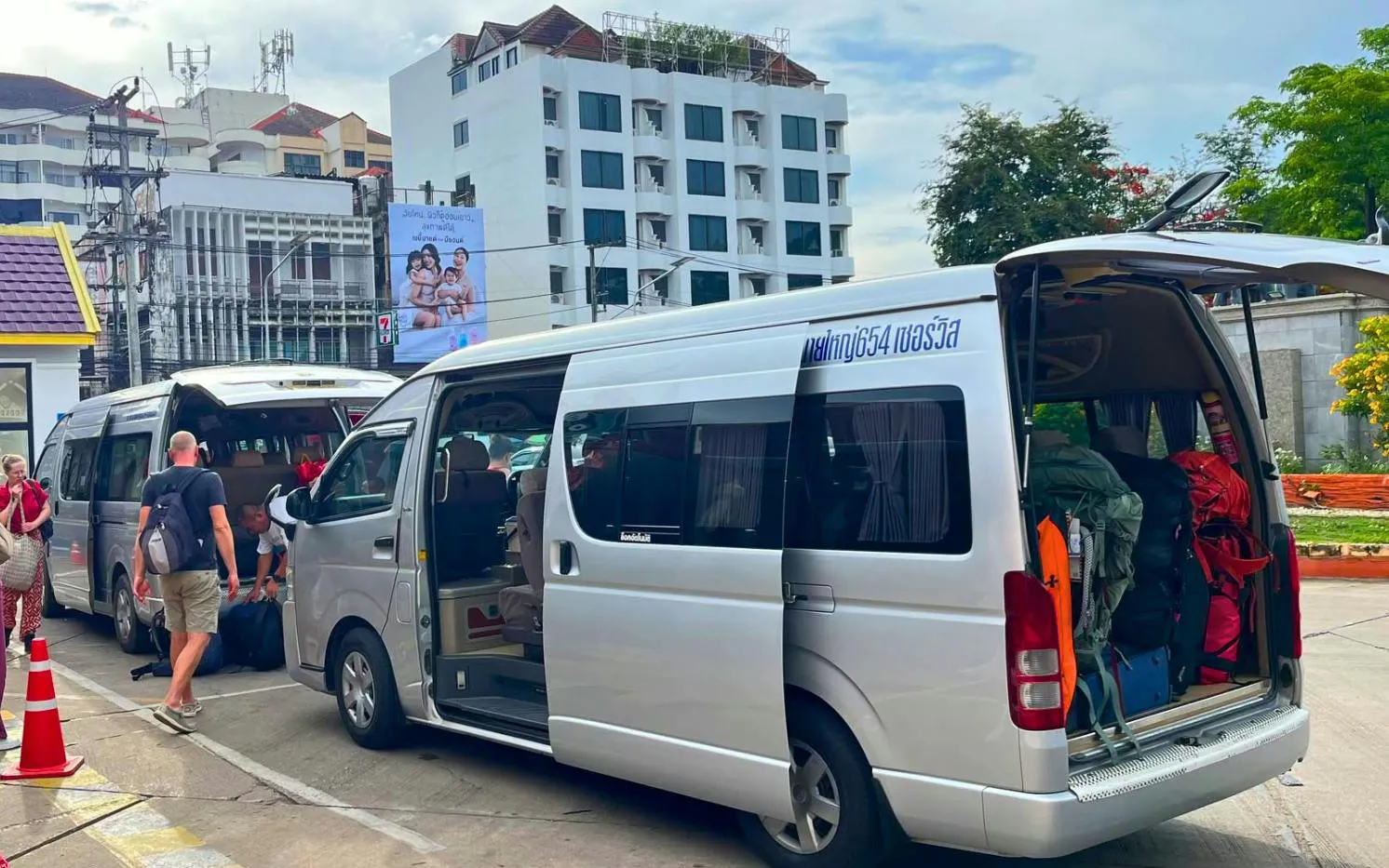 Minivans loading luggage for private transfer from Chiang Mai Airport to city hotel.
