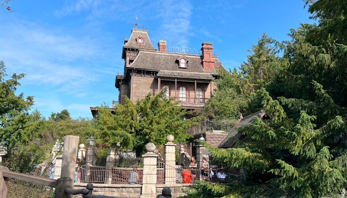 Phantom Manor at Disneyland Paris with eerie Victorian architecture and surrounding gardens.