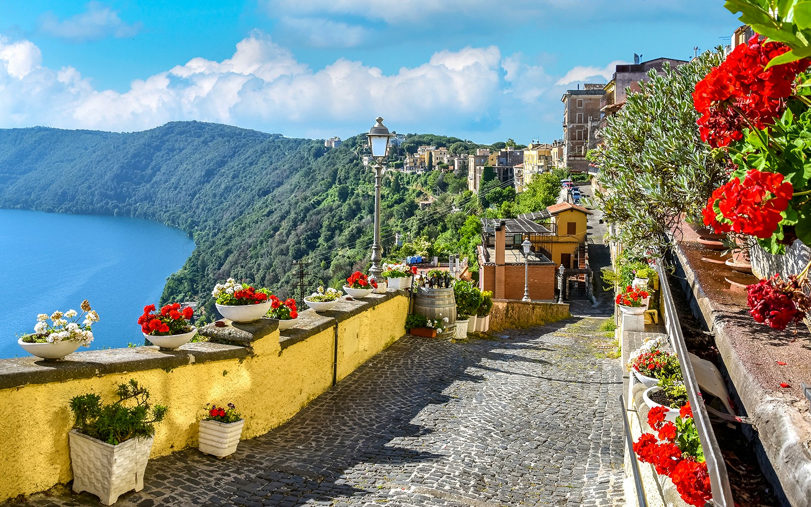 Cobblestone path with flowers overlooking Lake Albano near Castel Gandolfo, Italy.
