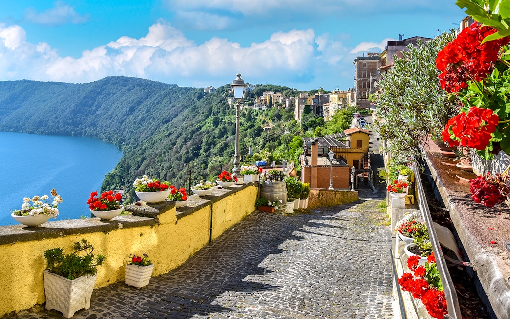 Cobblestone path with flowers overlooking Lake Albano near Castel Gandolfo, Italy.