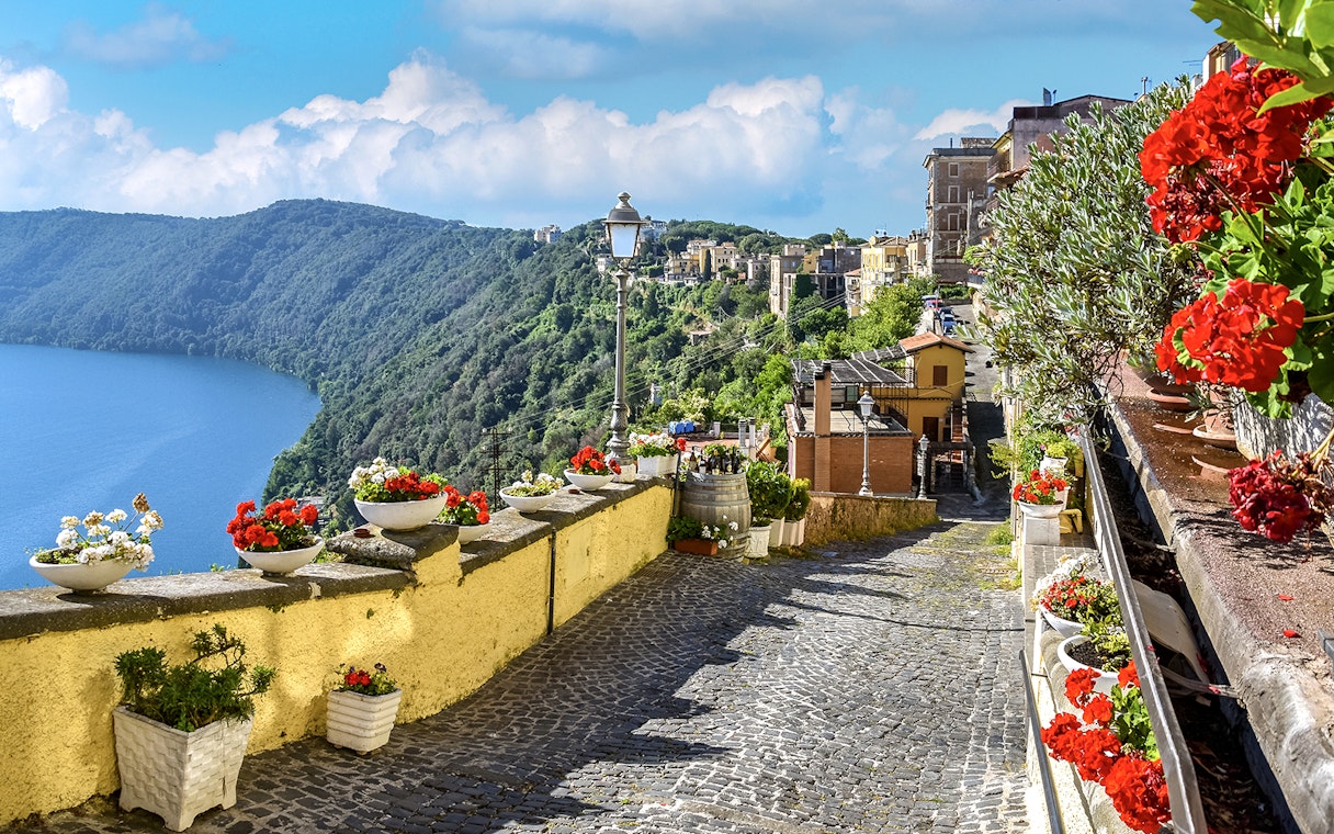 Cobblestone path with flowers overlooking Lake Albano near Castel Gandolfo, Italy.