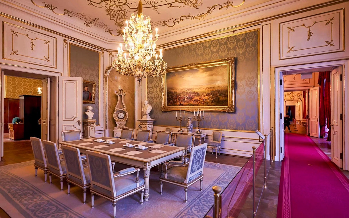 Dining room in the Imperial Apartments, Hofburg Palace, Vienna, featuring ornate chandelier and artwork.
