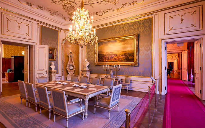 Dining room in the Imperial Apartments, Hofburg Palace, Vienna, featuring ornate chandelier and artwork.