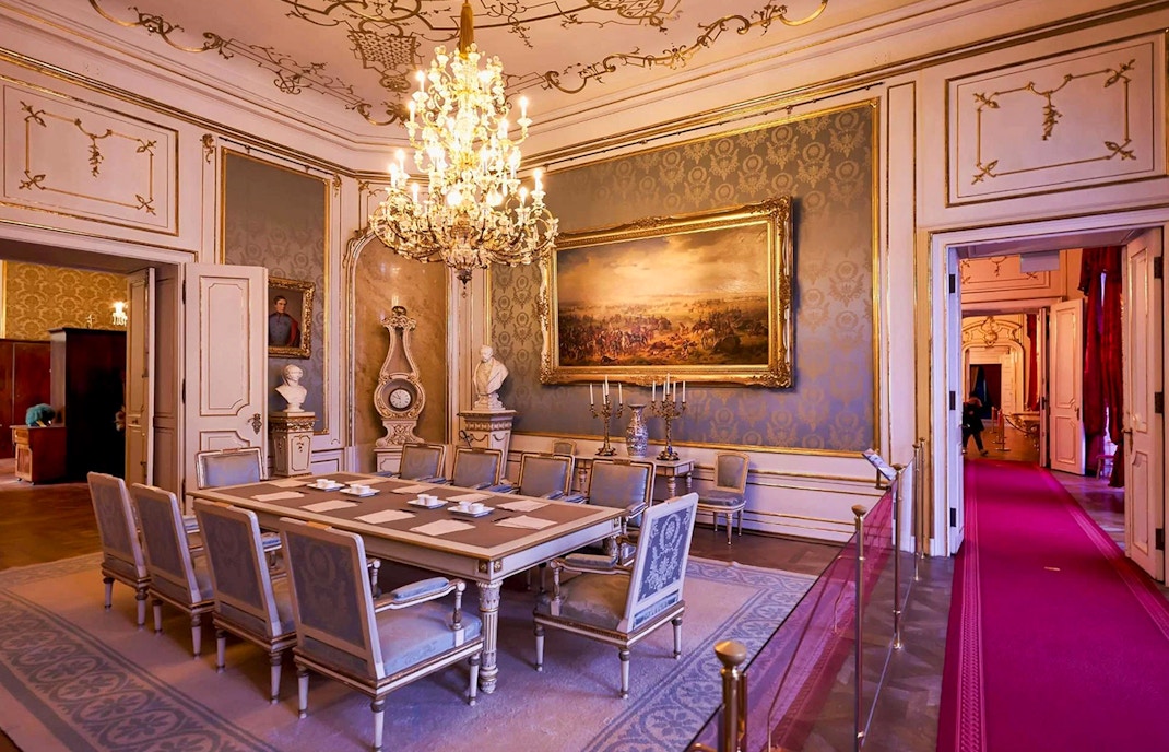 Dining room in the Imperial Apartments, Hofburg Palace, Vienna, featuring ornate chandelier and artwork.