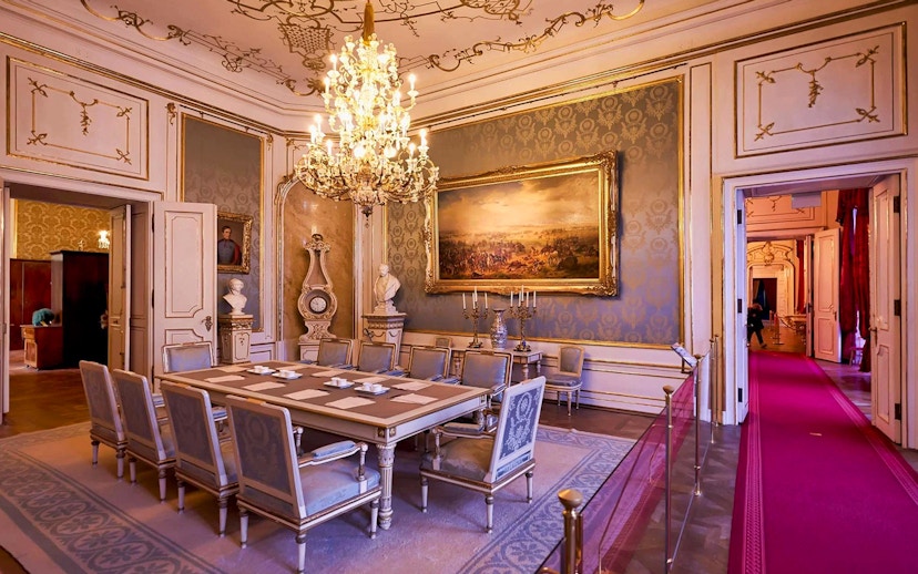 Dining room in the Imperial Apartments, Hofburg Palace, Vienna, featuring ornate chandelier and artwork.