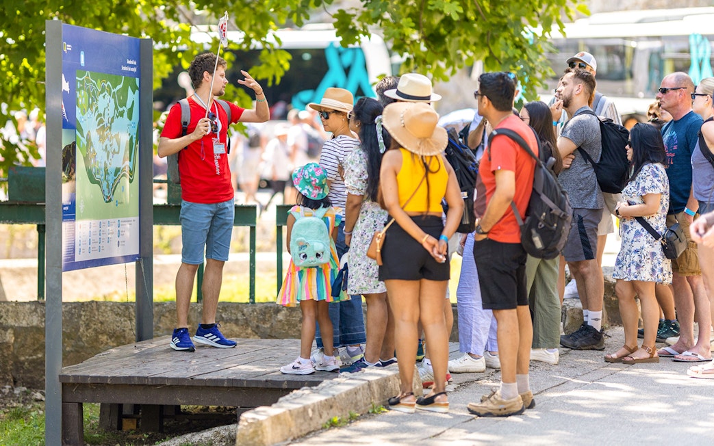 Tour group listening to a guide at Krka Waterfalls, Croatia.