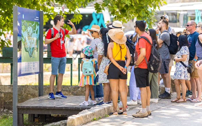 Tour group listening to a guide at Krka Waterfalls, Croatia.