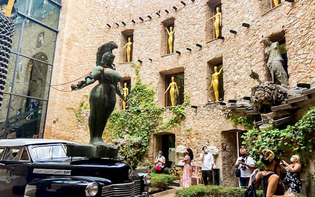 Sculpture and vintage car in courtyard of Dalí Museum, Figueres, Spain.