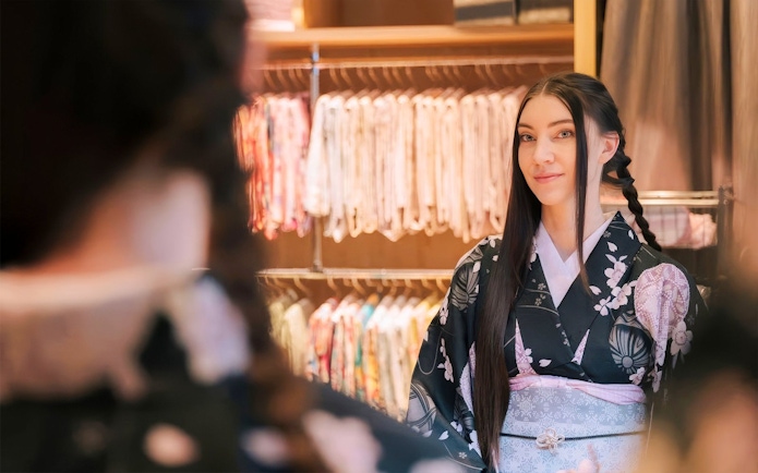 Tourist in kimono getting hair styled at rental service in Japan.
