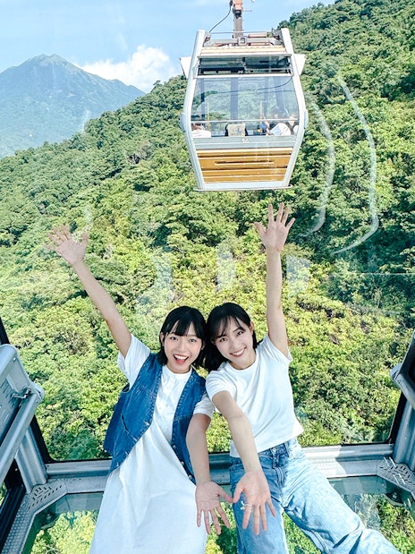 Tourists enjoying view inside cable car on Lantau Island Hop-on Hop-off Bus Tour.